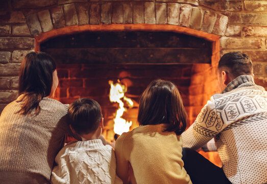 Family gathered at a warm brick fireplace in Valley Stream