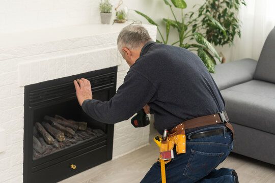 Technician fitting an insert into a white mantel fireplace